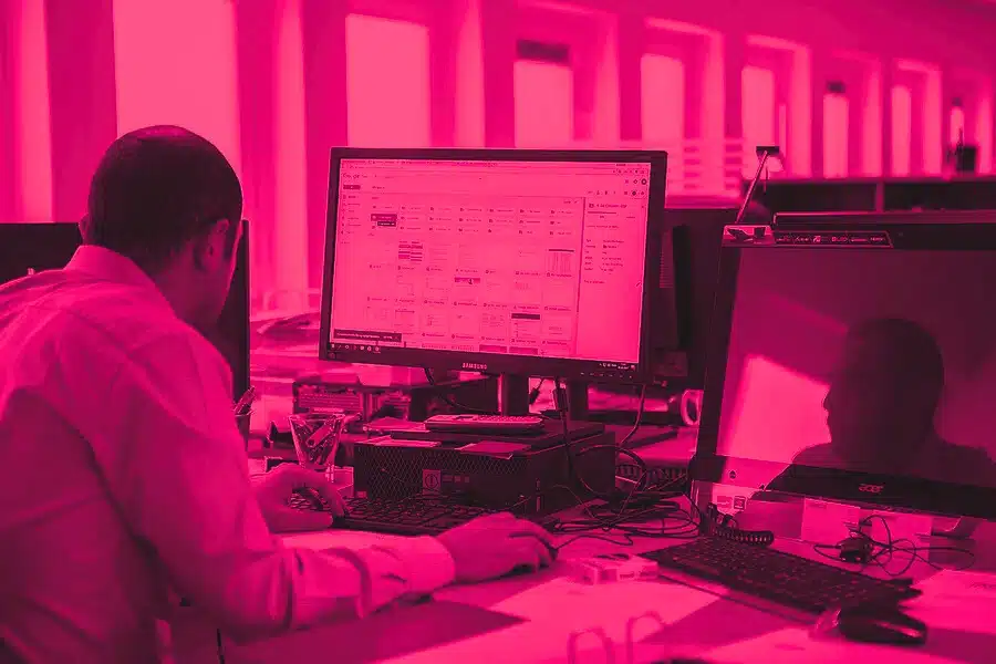 Dirigeant d'entreprise devant un ordinateur portable, en train de gérer les actifs logiciels de sa PME.